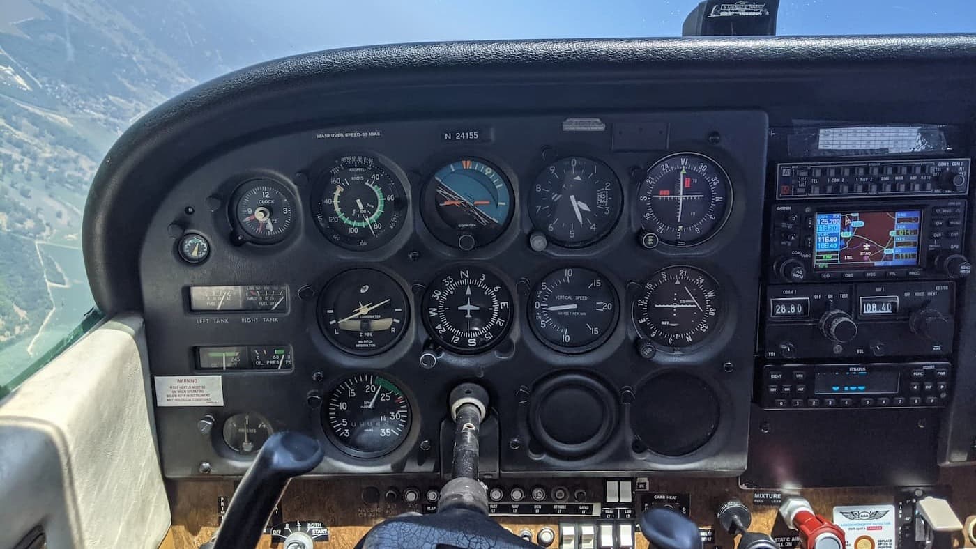 The analog cockpit of a Cessna 172, with the plane rolling slightly to the left.